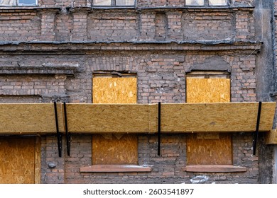 poor technical condition of the building. facade of an old shabby and destroyed residential building in the city. secured facade of the building. cheap apartments for rent and for purchase in old buil
