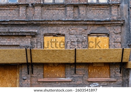poor technical condition of the building. facade of an old shabby and destroyed residential building in the city. secured facade of the building. cheap apartments for rent and for purchase in old buil