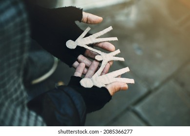 Poor Tired Depressed Hungry Homeless Man Holding A Cardboard Family. Nostalgia And Hope Concept.