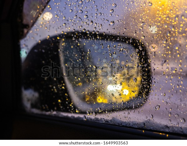 Poor visibility through the side window of\
the car. Bad weather conditions and caution when driving a car.\
Reflection in the rearview mirror. Careful driving in dangerous\
weather conditions.