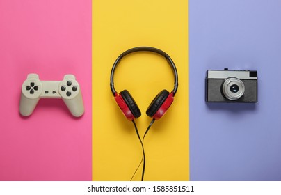 Pop culture attributes on a colored paper background. Gamepad, retro camera, headphones. 80s. Pop Art. Top view
