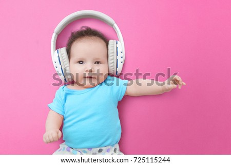 Pop Music Happy Smiling Newborn Baby Listens To Music In Headphones On Pink Background Pop Music Happy Smiling Newborn Baby Listens To Music In Headphones On Pink Background