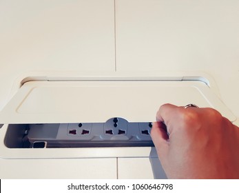 Pop Up Outlet Socket With Hand. Electrical Power Outlet With Dual 3 Pin, Phone Jack Plugs And Network Plugs On A White Table Background. Copy Space