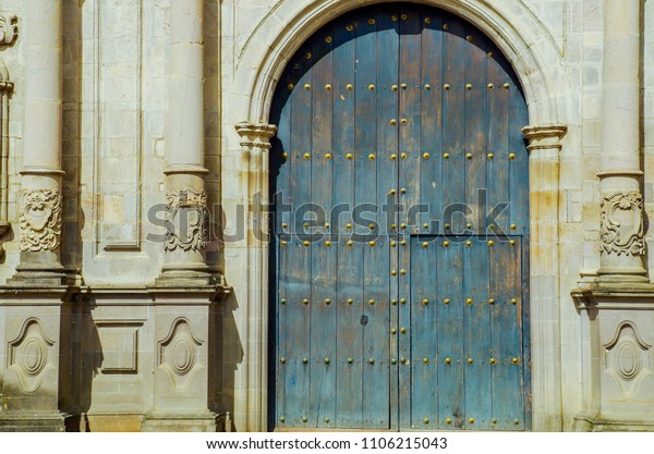 POPAYAN, COLOMBIA - FEBRUARY 06,\
2018: Outdoor view of carved columns and wooden huge green and\
rusted door of San Francisco church in colonial city\
Popayan