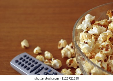 Popcorn In A Bowl Next To A Tv Remote Controller