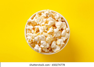 Popcorn Bowl Viewed From Above On Yellow Background. Flat Lay. Top View