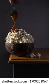 Popcorn In A Coconut Bowl With A Caramel Drizzle. Pour Photography. 