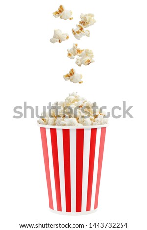 Popcorn falling into a red striped paper cup, isolated on white background