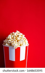 Popcorn In A Glass On A Red Background. Salted Caramel Popcorn With Bacon And Cheese. Going To The Cinema. Snacks Are Delicious In A Glass. Red Background Place For Copywriting. Candy In Kina. Food 