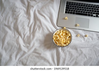 Popcorn And Laptop On The Bed. Movie Watching Concept