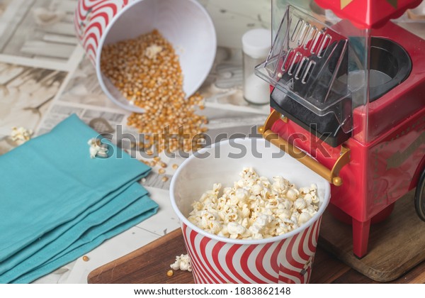 popcorn machine and\
bucket on a wooden\
table