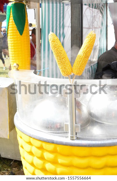 Popcorn machine during\
food festival, street food or carnival event. Sweet corn or kernel\
boiling machine outdoor setting. Yellow fresh kernels preparation\
or cooking