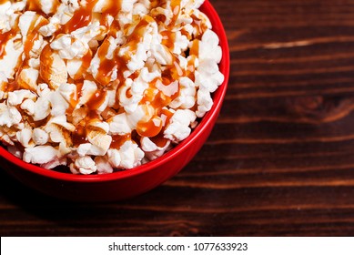 Popcorn In A Red Bowl Of Poured Caramel, On A Dark Table