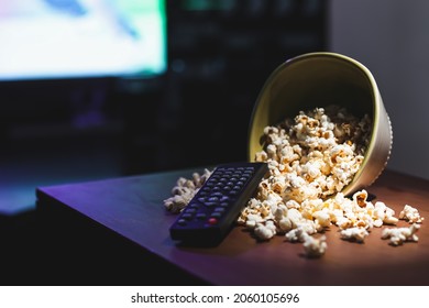 Popcorn and remote control on table in room - Powered by Shutterstock