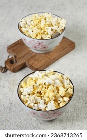 Popcorn is a snack made from dried corn kernels, then heated with butter, eaten while watching a film - Shutterstock ID 2368713265