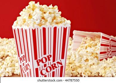 Popcorn still life of classic containers overflowing with freshly popped corn against a red background.  Macro with shallow dof. - Powered by Shutterstock