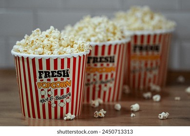 Popcorn in a striped box on a wooden table. Selective focus. Delicious fast food - Powered by Shutterstock