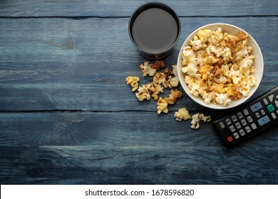 Popcorn And Tv Remote Control On A Blue Wooden Table. Concept Of Watching A Movie Or Video At Home. Top View