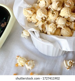 A Popcorn In A White Cup On A White Table With A Truffle Butter Alongside