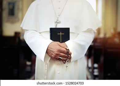 Pope holding a Bible in the church
