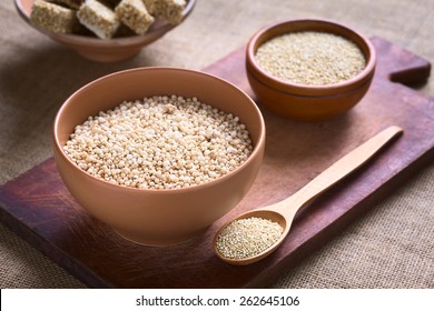 Popped White Quinoa (lat. Chenopodium Quinoa) Cereal In Bowl With Raw Quinoa Seeds In The Back Photographed With Natural Light (Selective Focus, Focus One Third Into The Quinoa Cereal)