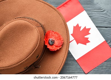 Poppy Flower With Hat And Flag Of Canada On Wooden Background. Remembrance Day