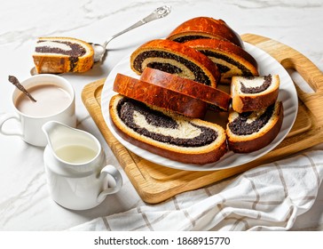 poppy seed strudel on a white plate with hot cacao drink in a cup on a marble table, strudla od maka, croatian recipe, horizontal view from above