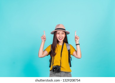 Poprtrait Asian woman traveler with cheerful feeling over blue background with copy space for summer travelling concept