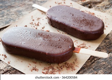 popsicle with grated chocolate on a wooden background