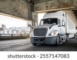 Popular bonnet powerful big rig semi truck tractor with high cab for long haul freights transporting commercial cargo driving on two level arched Fremont bridge across Willamette river in Portland