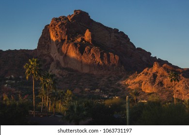 Popular Camelback Mountain with patches of sunlight cast upon the peak at sunrise, Paradise Valley, Arizona