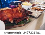 The popular, delicious and crispy roasted pig known as "lechon baboy" (in the Philippines, Spain, Cuba, etc.) on the buffet table of Filipino dishes. Selective focus. Copy space.
