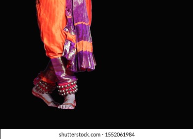 Popular Famous Posture Of Indian Classical Bharat Natyam Dancer In Orange Costume And Ghunghru