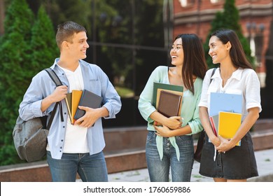 Popular Guy In Campus. Handsome University Student Chatting With Two Female Classmates Outdoors