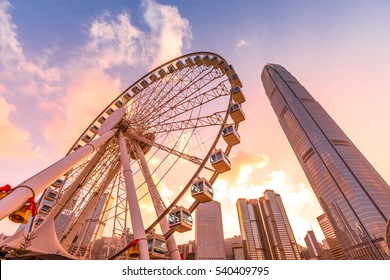 The popular icon Observation Wheel in Hong Kong island at sunset near Ferry Pier arera with landmark buildings in background.