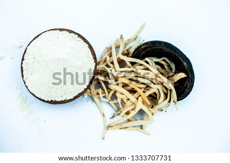 Popular Indian & Asian ayurvedic herb isolated on white in a clay bowl i.e. Musli or safed musli or Chlorophytum borivilianum with its powder in a clay bowl used in many ayurvedic medicines. Stock photo © 