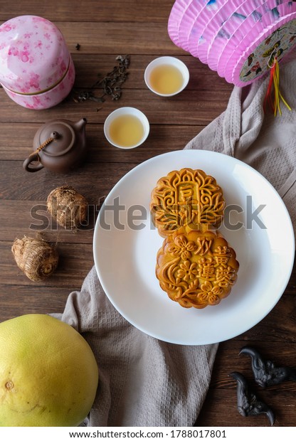 Popular mid autumn food items and lanterns display\
/ Mooncake, Chinese Tea, Taro, Water Caltrop and Lanterns / The\
chinese characters translates as double egg yolk lotus paste and\
red bean paste
