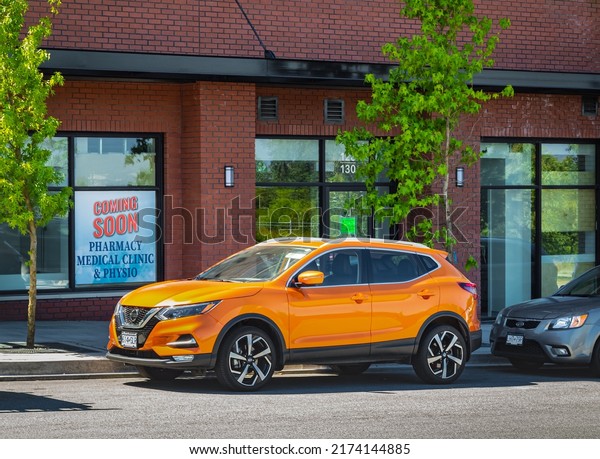 Popular new offroad car crossover parked on a\
street. Orange metallic color Japanese SUV Nissan X-Trail, drive\
4x4 all wheel-June 24,2022-Vancouver BC Canada-Street photo,\
nobody, selective focus