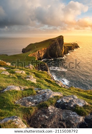 Popular sightseeing destination Neist Point Lighthouse on the beautiful Isle of Skye, Scotland, UK. Scottish coastal landscapes with golden evening light.