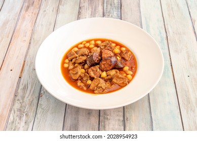 Popular Spanish Stew Of Tripe With Chickpeas And Pieces Of Chorizo And Blood Sausage On A White Porcelain Plate