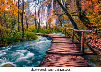 Popular touristic wooden bridge in the colorful autumn deep forest. Wooden promenade with clean brook and spectacular waterfalls, Plitvice National Park, Croatia, Europe