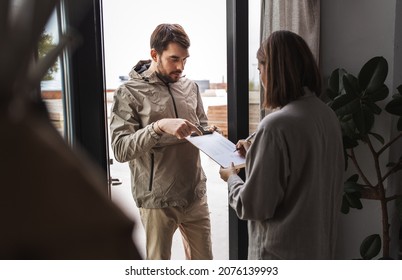 Population Census, Polling And People Concept - Male Social Worker Asking Woman Sign Papers On Clipboard At Home