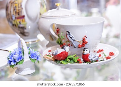 Porcelain cup and saucer with red rowan and figurines of bullfinches.