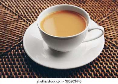 Porcelain Cup Of Tea With Milk On Wicker Background