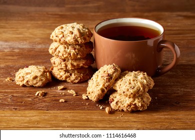 Porcelain cup of tea and sweet cookies on wooden background, top view, selective focus