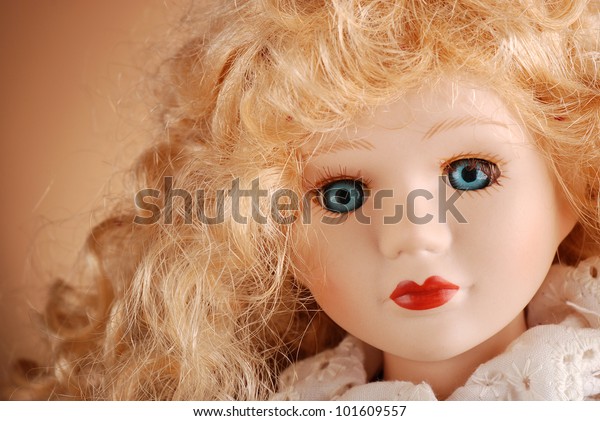 porcelain doll with blonde hair and blue eyes