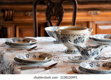 Porcelain tableware. Table service set on the table. Old plates and spoons. An elegantly set table.
