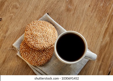 Porcelain teacup with chocolate chips cookies on cotton napkin on a rustic wooden background, top view - Powered by Shutterstock