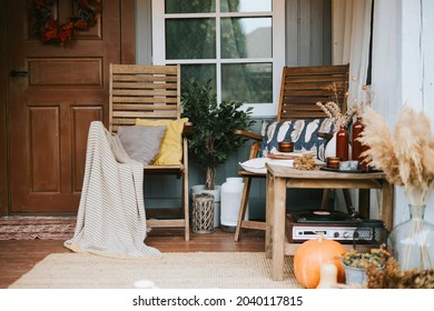 Porch Of The Backyard Decorated With Pumpkins And Dry Grass In Autumn, Rustic Furniture On Veranda Of A Rustic House, A Cozy And Stylish Interior In Autumn Colors