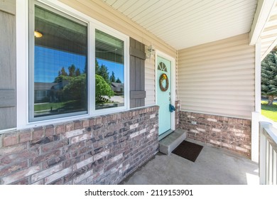 Porch Of A House With Mint Green Front Door With Wreath, Glass Panel And Two Lockboxes